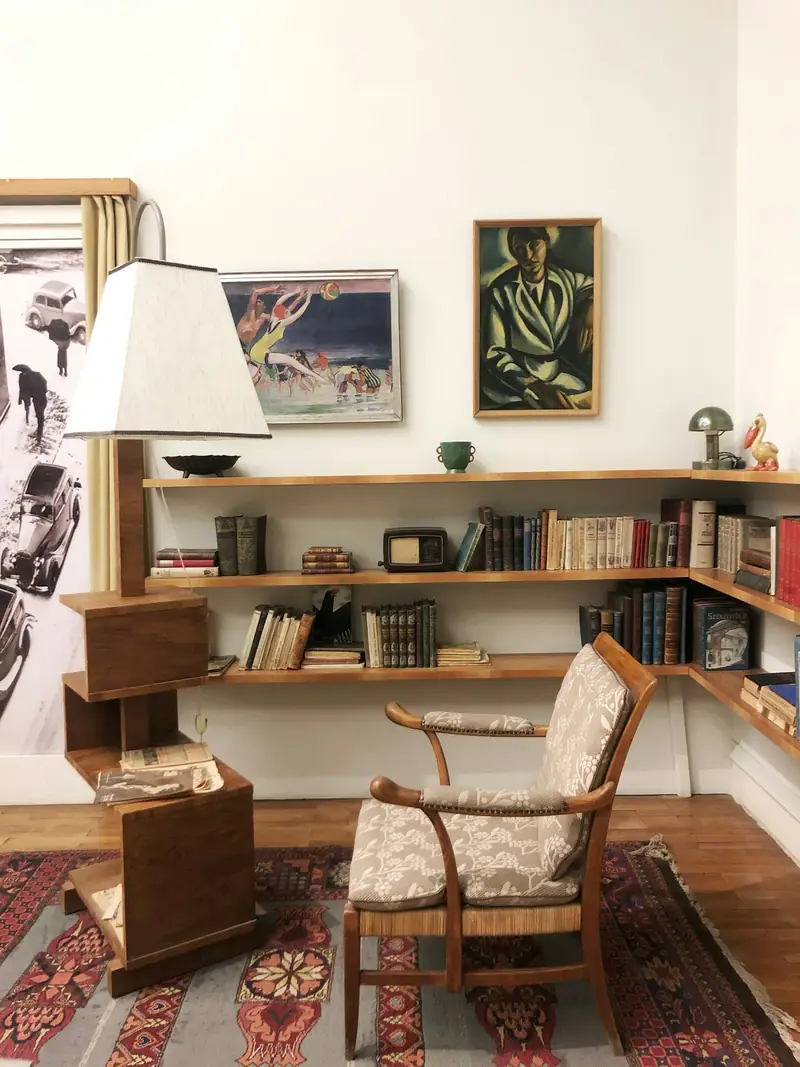 Korbsessel vor einem Bücherregal in einer älteren Wohnung